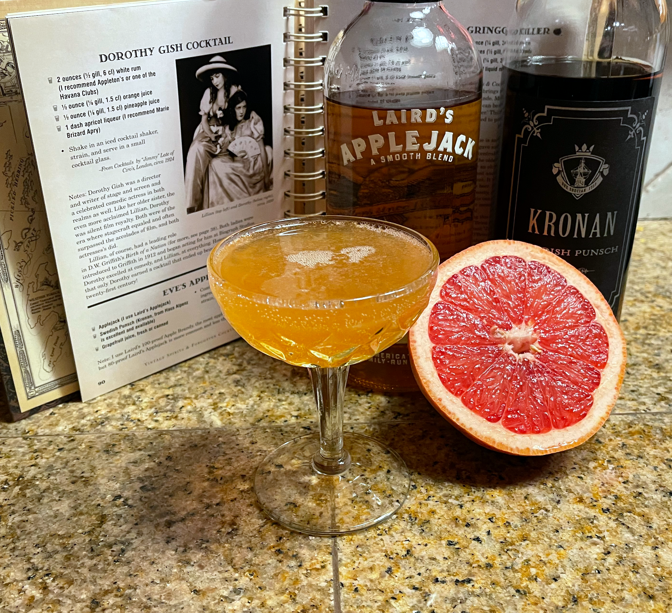 Eve’s Apple - an orange colored cocktail in a coupe glass with faceted sides